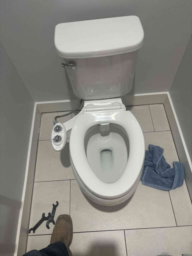 Toilet in a bathroom after a replacement service.