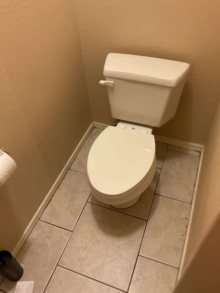 Toilet in a bathroom after a replacement service.