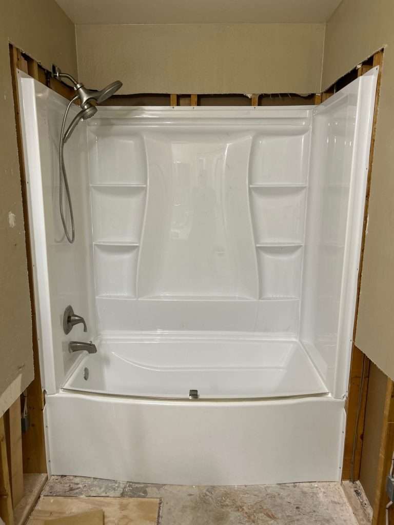 White shower-bathtub combo after plumbing repairs.